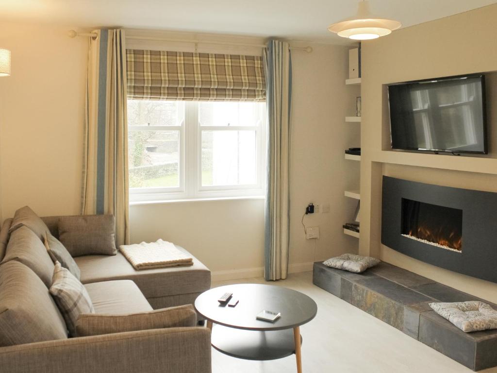 a living room with a couch and a fireplace at 12A Elm Court in Keswick