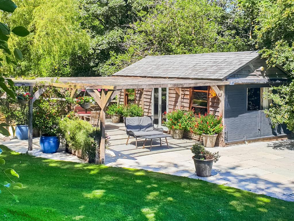 a backyard with a pergola and a chair on a patio at Willow's Rest in Crafthole