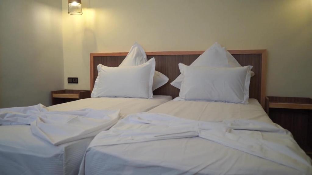 two beds with white sheets and pillows at Surf House Dakhla in Dakhla