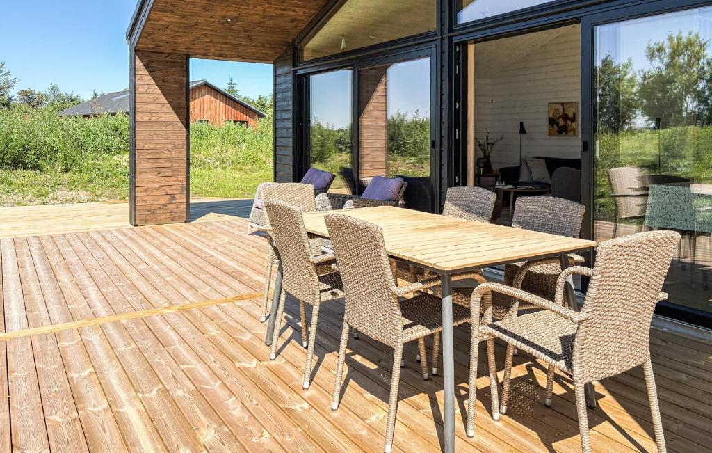 a wooden table and chairs on a wooden deck at 3 Bedroom Beautiful Home In Fjerritslev in Fjerritslev