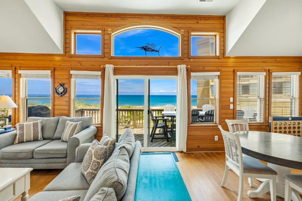 a living room with a view of the ocean at 7000 - Serenity Sands in Whalebone