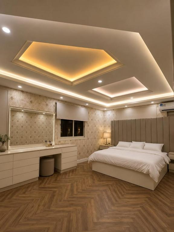 a bedroom with a large bed and a bath tub at شقق رواق in Abha