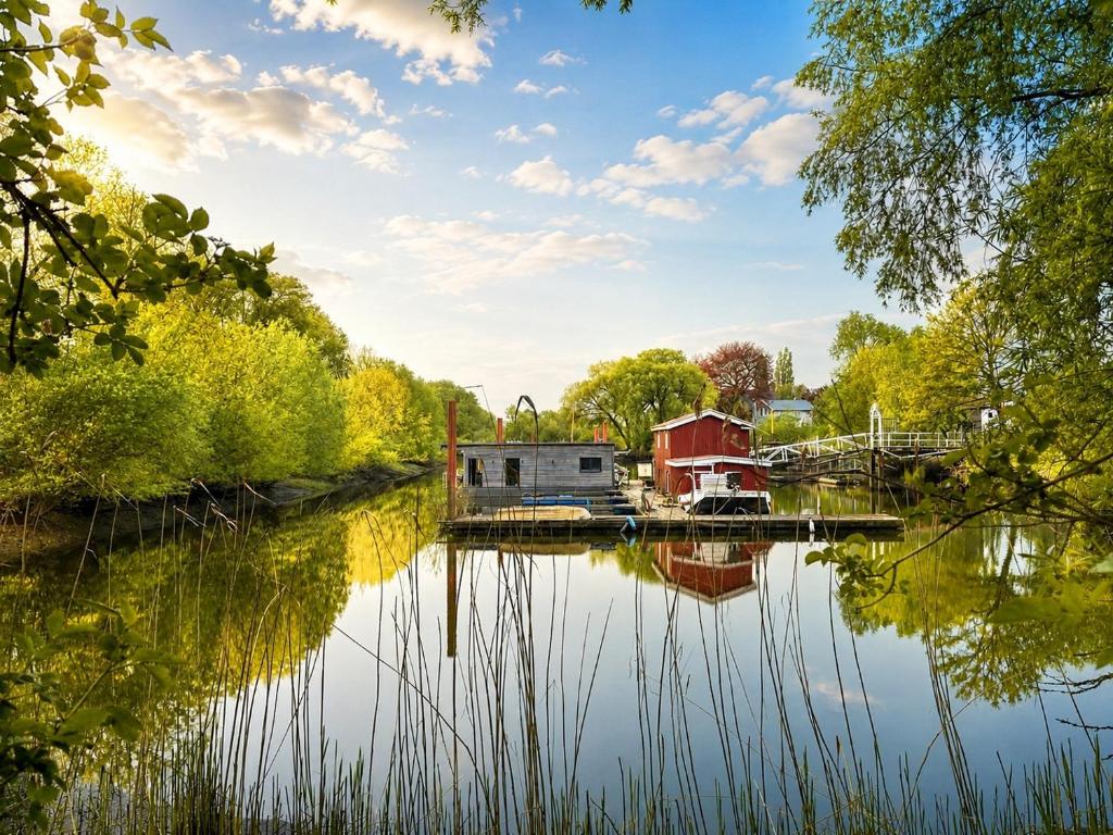 a view of a river with houses and trees at Hausboot Stöckte in Winsen