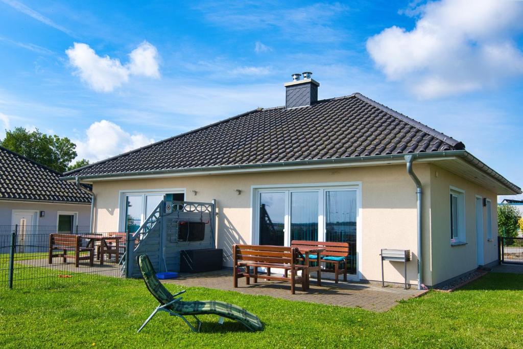 a house with a bench and a table in a yard at Ferienhaushälfte "Ausblick" in Sundhagen-Niederhof