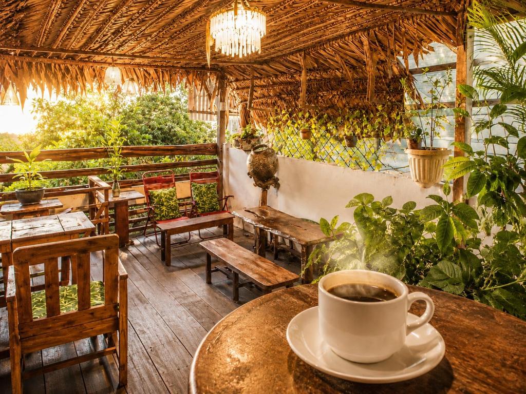 a cup of coffee on a table in a restaurant at Feliz Puerta - Entire House with Rooftop Terrace, Iquitos in Iquitos