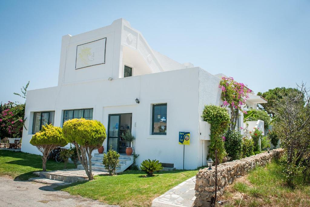 a white house with a clock on it at Ilios and Irene 5 in Mastihari