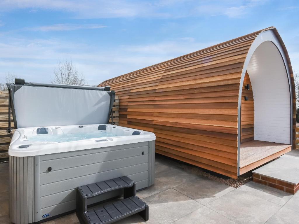 a hot tub sitting next to a wooden wall at Squirrels Retreat - Uk46127 in Nesscliffe