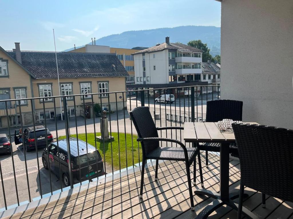 a balcony with a table and chairs and a view of a street at Spacious Apartment - Prime Voss Location - Elevator in Vossevangen