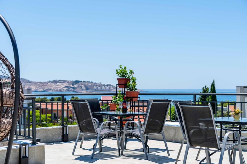 a table and chairs on a balcony with a view of the ocean at Apartments Sarić in Bar