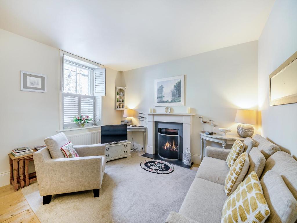 a living room with a couch and a fireplace at Chareside Cottage in Corbridge