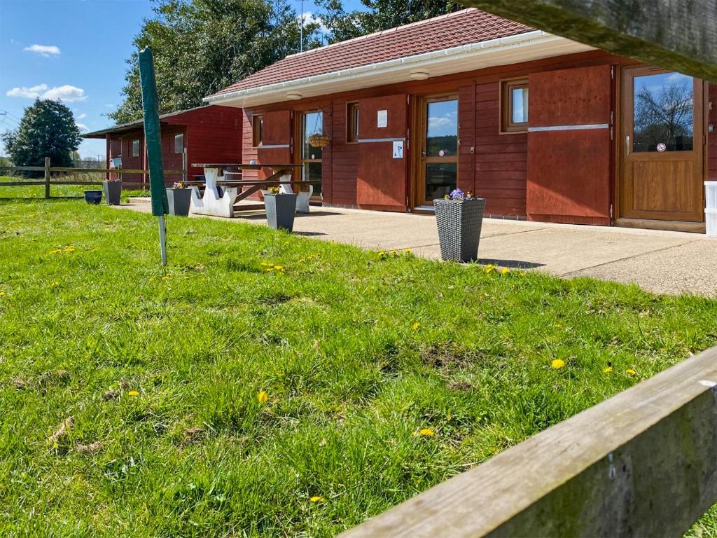 a building with a grassy field in front of it at Sherwood Forest Lodge 2 in Clipstone