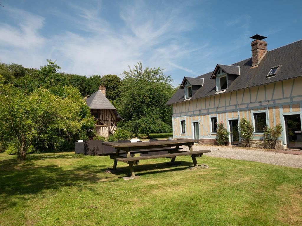 a picnic table in the grass in front of a building at La longère in Flancourt-Catelon