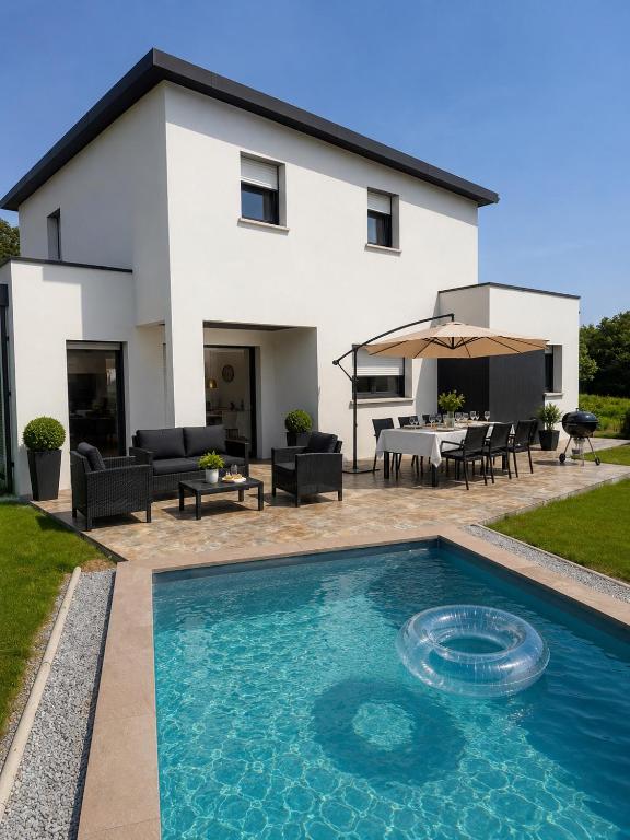 a house with a swimming pool in front of a house at L Œil de L Horizon in Lanildut