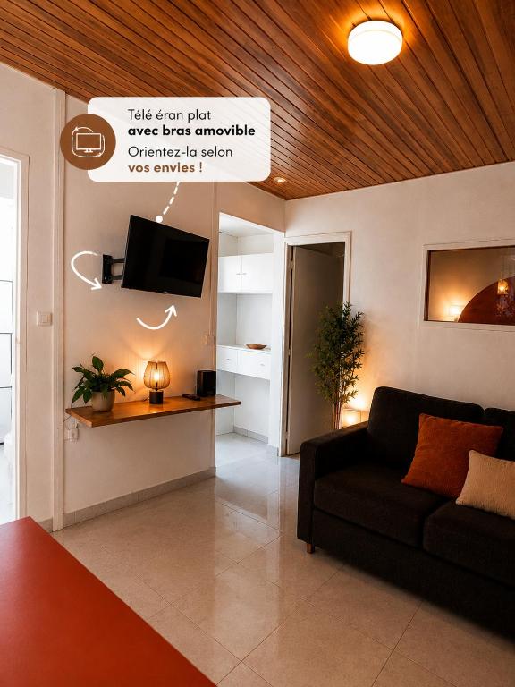 a living room with a couch and a tv at URBAN LOFT- Espace détente in Fort-de-France