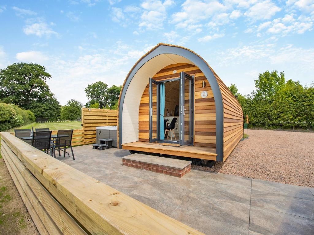 a small wooden cabin with a table and chairs at Rabbits Rest - Uk46128 in Nesscliffe