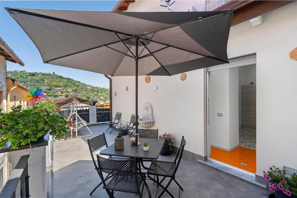 a patio with a table and chairs and an umbrella at La Casa Di Zio Michelino in Pimonte