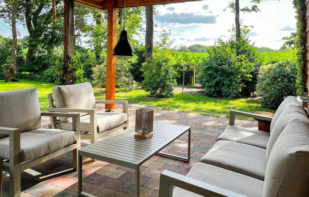 a patio with couches and a table and chairs at Buitengoed Het Lageveld - 56 in Hoge-Hexel