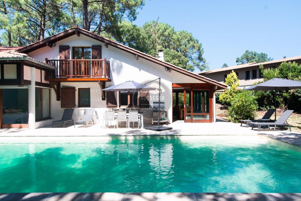 a house with a swimming pool in front of a house at Villa Igelak - Hossegor - Centre - Lac - Piscine in Soorts-Hossegor