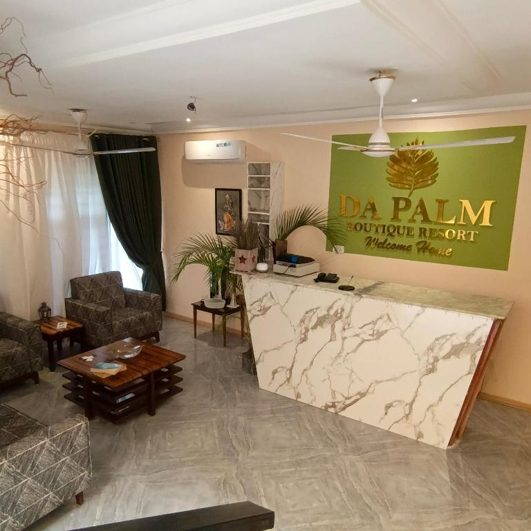 a living room with a table and a sign on the wall at Da Palm boutique resort in Aburi