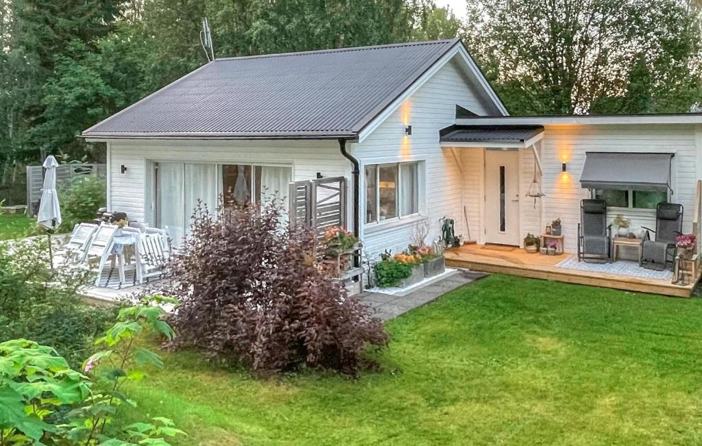 a small white house with a porch and a deck at Amazing Home In Luleå With Sauna in Luleå