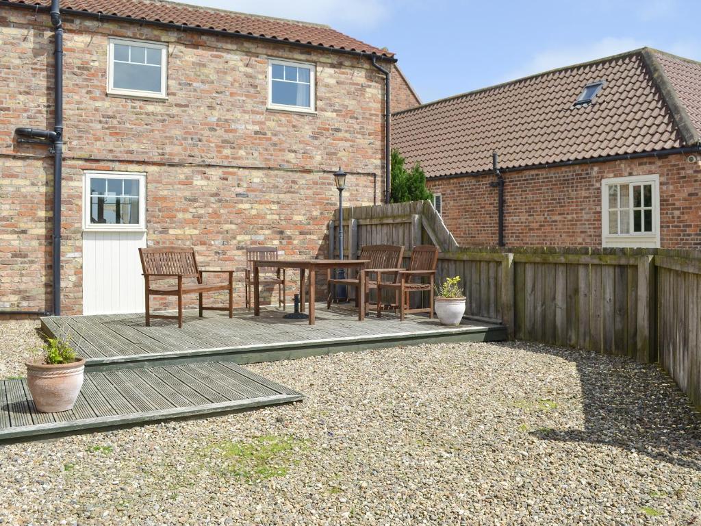 a patio with chairs and a table in front of a building at Four Bays - Ioh in Brandesburton