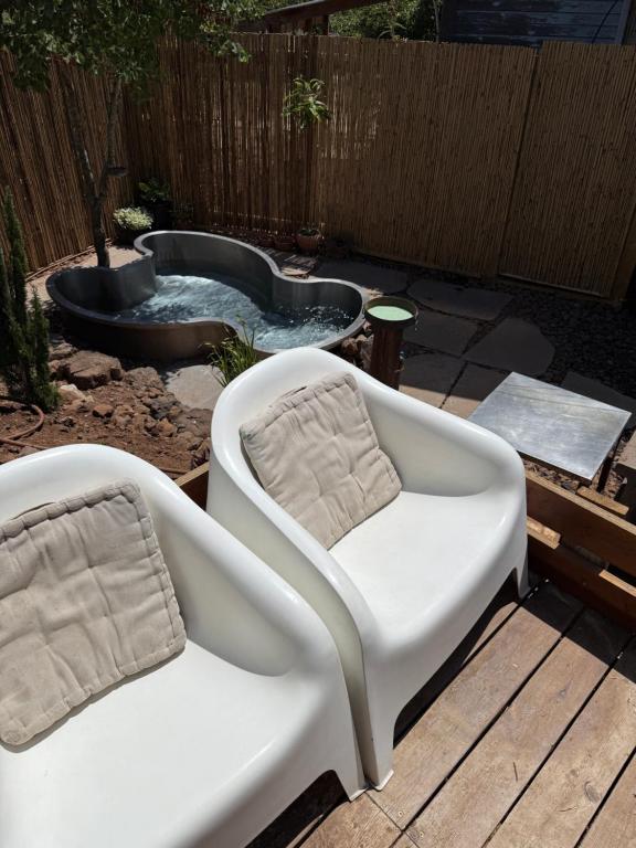a white chair sitting on a deck next to a hot tub at Healing Hands in Merom Golan