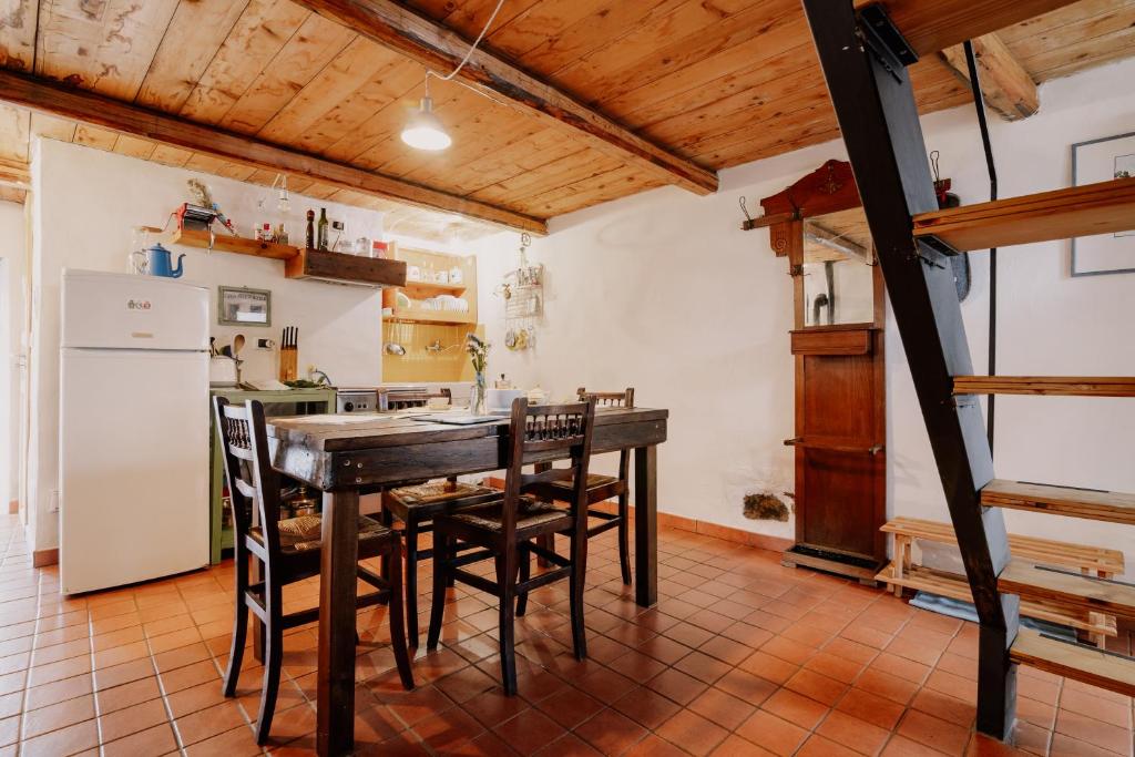a kitchen with a table and chairs and a refrigerator at Casa Acquarossa in Rubiana