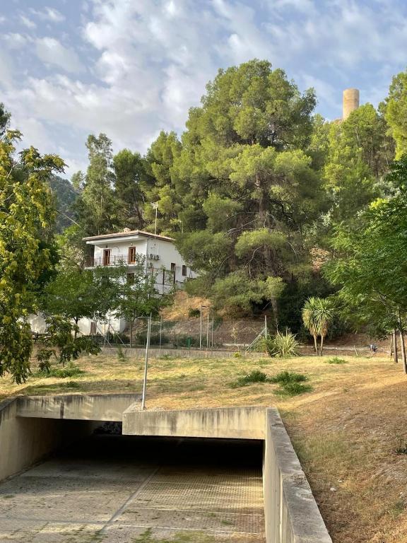 a bridge over a river with a house in the background at El balcón de Cuadros in Jaén