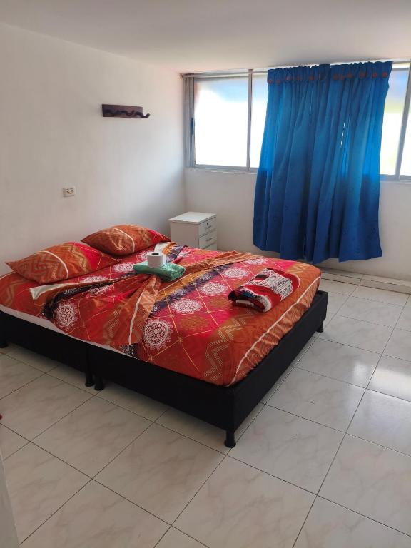 a bedroom with a bed with a blue curtain at Hotel y restaurante juanchito in Pitalito