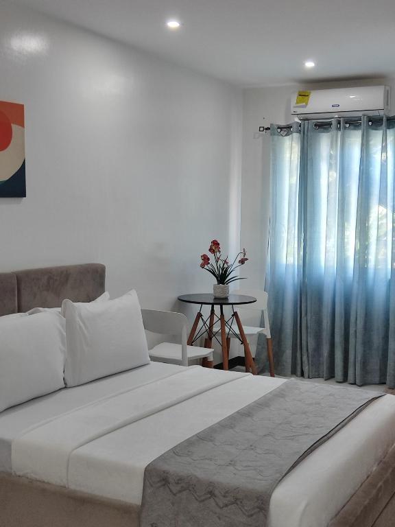 a bedroom with a large white bed and a table at Ricres Hometel R3 in Babak