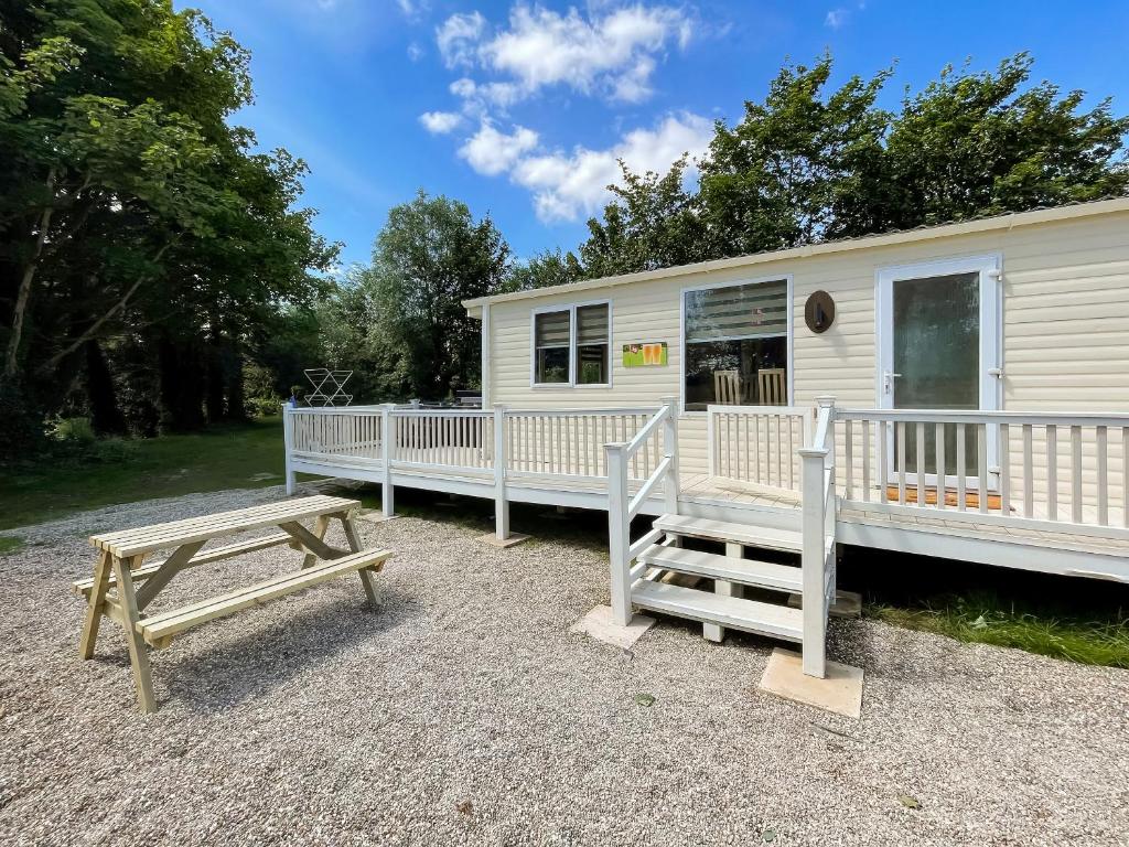 a mobile home with a picnic table and a bench at Shirley's Haven - Uk46631 in Brigham