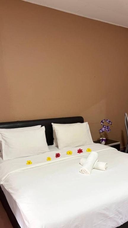 a white bed with flowers on top of it at Bunga Raya Resort Parit Buntar in Parit Buntar
