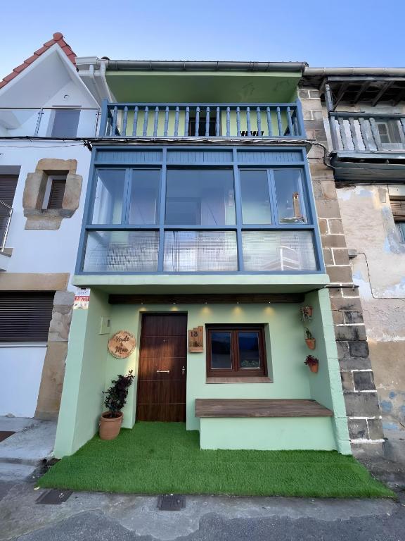 a house with a balcony on top of it at Verde & Mar in Castro-Urdiales