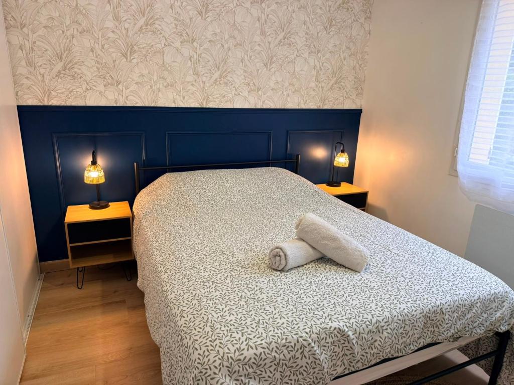 a bedroom with a bed with a towel on it at La Parenthèse de Quantilly in Quantilly