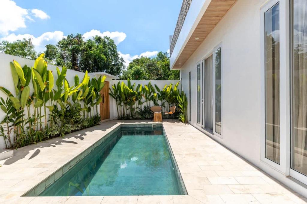 a swimming pool in the backyard of a house at Villa Candi - Stylish Tropical Pool Villa in Ungasan