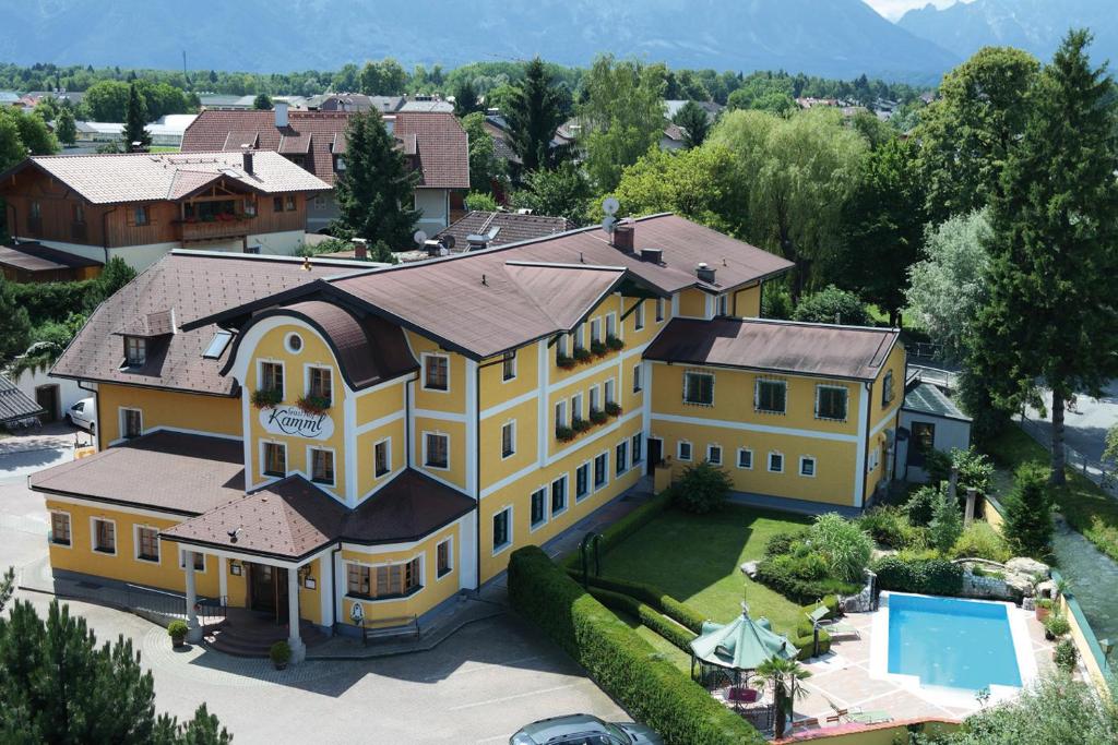 an aerial view of a large yellow house with a swimming pool at Hotel Gasthof Kamml in Wals