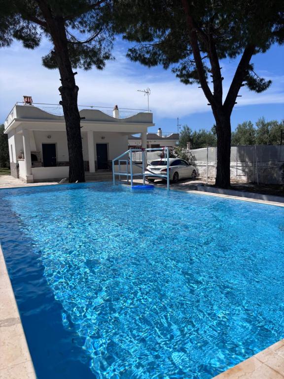 a large blue swimming pool in front of a house at Sant'Angelo Country House in Trani