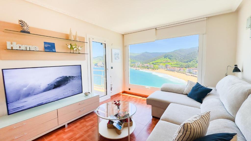 a living room with a large tv and a couch at El BALCON DE BAKIO in Bakio