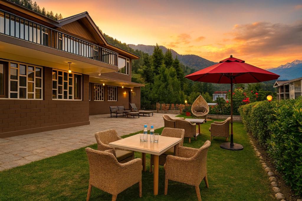 a patio with a table and chairs and an umbrella at Manu Villa Manali - A Beautiful Cottage towards Snow Capped Mountain in Manāli