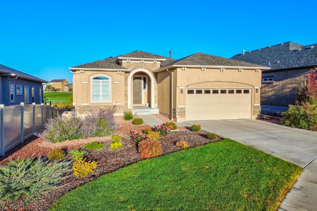a brick house with a garage in a yard at Home w/ Golf Course, Mountain Views & EV Charging! in Peyton