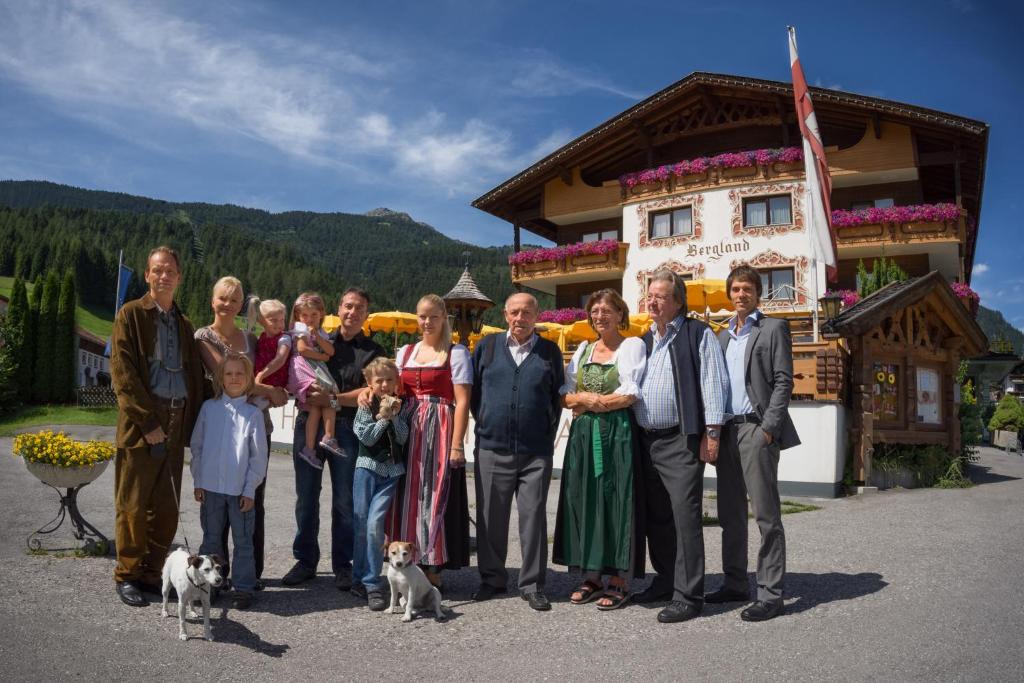 a group of people posing for a picture in front of a building at Hotel Bergland in Lermoos