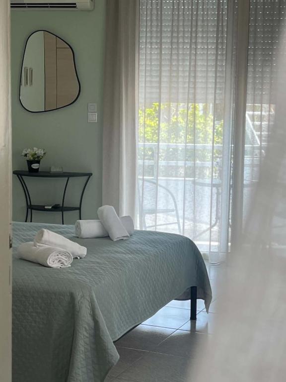 a bedroom with a bed and a large window at Studio Nefeli - Heart of Archangelos in Archangelos