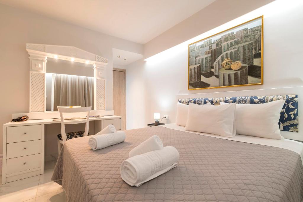 a bedroom with a bed with white pillows and a desk at A&B Rooms Rodos Center in Rhodes Town