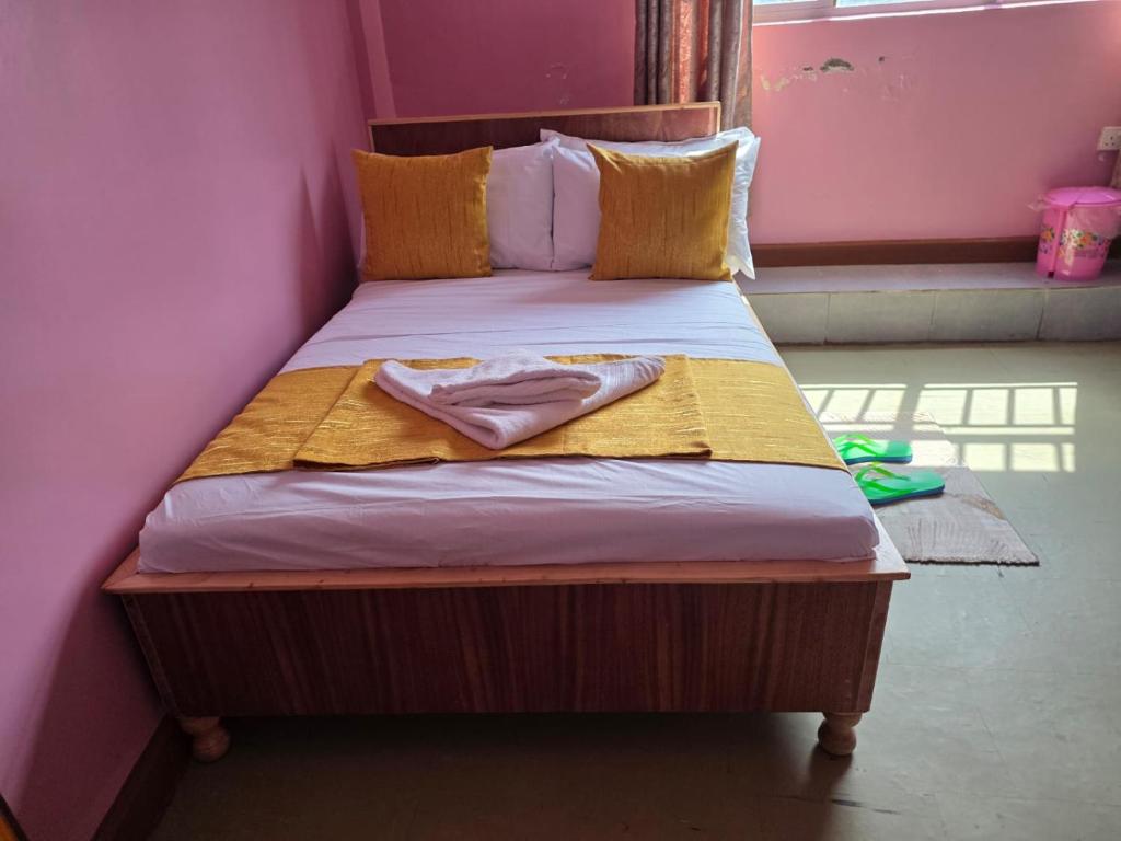 a bed in a pink room with a bedspread at EMJAYS guest house in Eldoret
