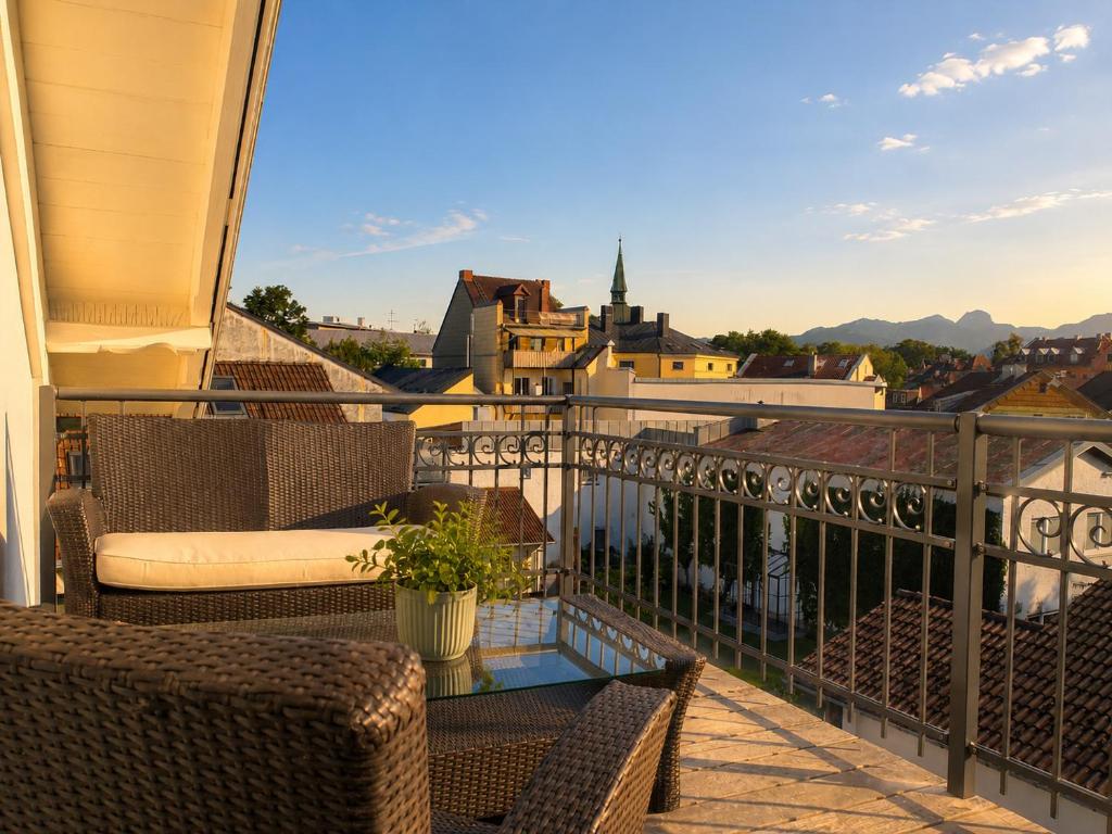 a balcony with two chairs and a glass table at Bad Aibling City Apartment - Pano in Bad Aibling