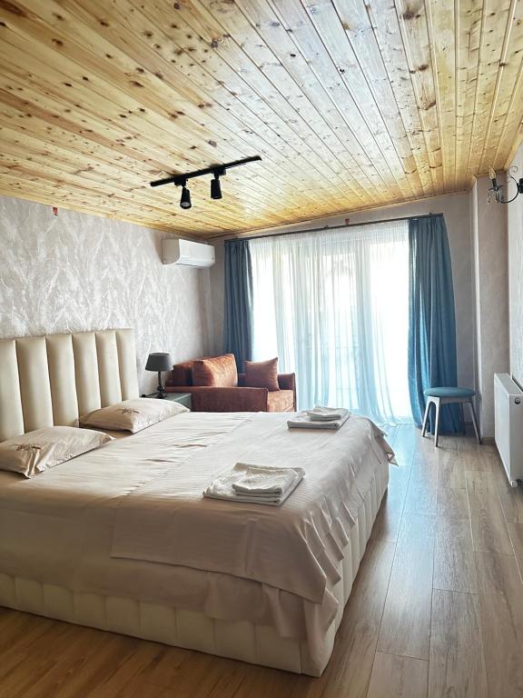a bedroom with a large white bed and a couch at Davit batoni Apartment in Mtskheta in Mtskheta