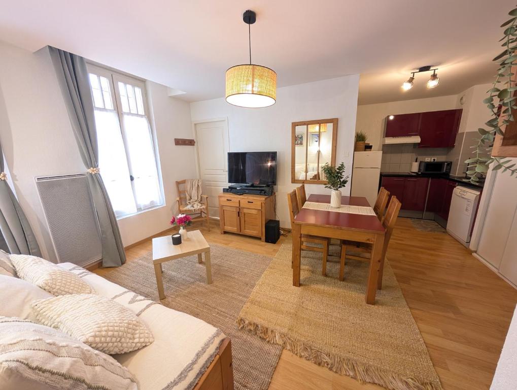 a living room with a table and a kitchen at Cocon Luchon in Luchon
