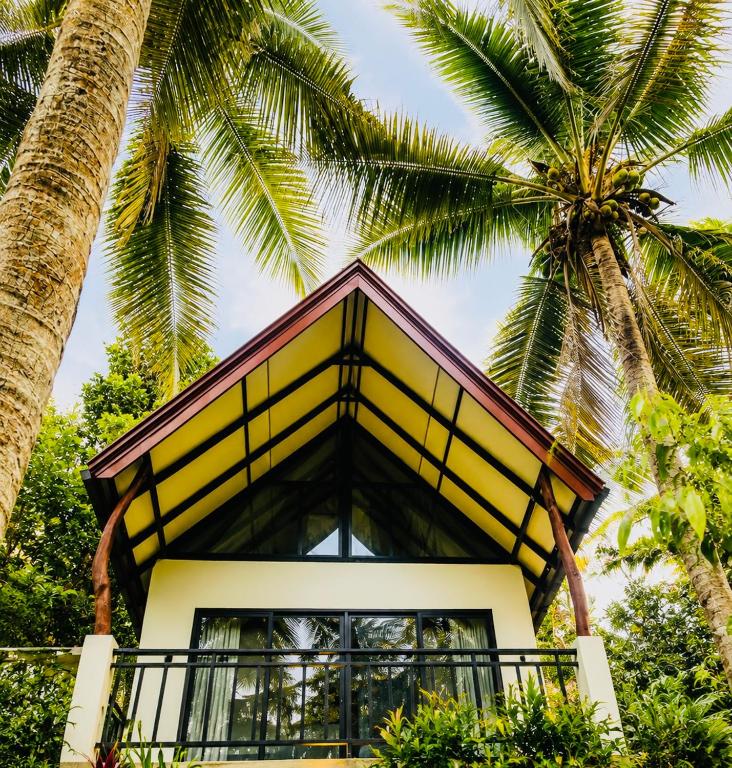 a house with palm trees in front of it at Rainforest Mountain Escape - Lankagama in Deniyaya