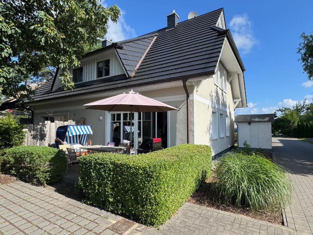 a house with a table and an umbrella in front of it at 8 kleine Heringe in Wieck