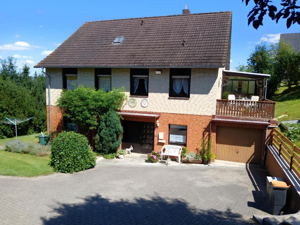 a large house with a balcony and a driveway at FeWo Waldblick in Salzhemmendorf